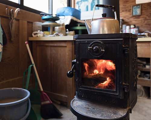Sometimes his beloved cats make an appearance in his work area, with its wood stove.