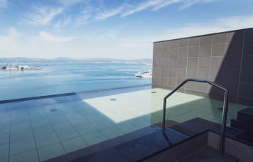 我們在頂樓18樓的大浴場打造與風景融為一體的無邊際浴池。